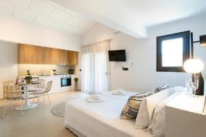 ein weißes Zimmer mit einem Bett und einer Küche in der Unterkunft Chrissomalli Sofia Studios in Skiathos-Stadt