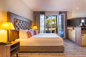 a hotel room with a large bed and a television at Lindner Hotel Mallorca Portals Nous, part of JdV by Hyatt in Portals Nous