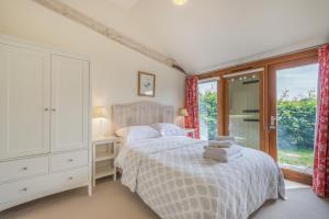 a bedroom with a bed and a large window at Chestnut Lodge in East Dean
