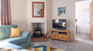 uma sala de estar com um sofá azul e uma televisão em Thirlmere em Sawrey