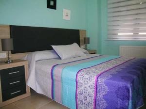 a bedroom with a large bed with a colorful blanket at AP. FORCELLEDO in Posada de Llanes