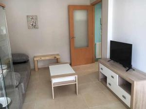 a living room with a flat screen tv and a couch at AP. FORCELLEDO in Posada de Llanes