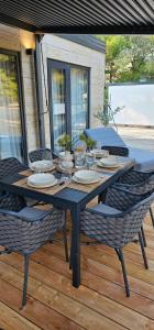 a black table with chairs and plates on a deck at MH Holiday Dream - Morning Sun in Drage