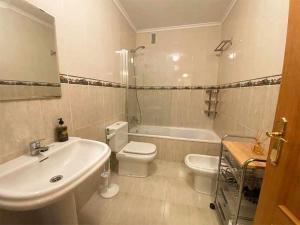 a bathroom with a sink and a toilet and a tub at "EL TAYUELO" in Posada de Llanes