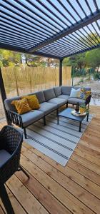 a patio with a couch and a table on a deck at MH Holiday Dream - Morning Sun in Drage