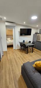 een woonkamer met een bank en een tafel en een slaapkamer bij MH Holiday Dream - Morning Sun in Drage