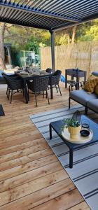 un patio con mesas y sillas en una terraza de madera en MH Holiday Dream - Morning Sun, en Drage