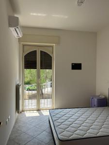 - une chambre avec un lit et une porte coulissante en verre dans l'établissement Le casette di Marittima, à Marittima