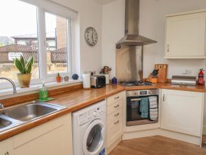 une cuisine avec un évier et une machine à laver dans l'établissement White Feathers, à Alnwick 6 autres photos