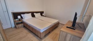 a bedroom with a bed and a television on a table at VILA DVG II in Costinesti