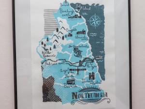 une carte de l'Irlande du Nord encadrée dans un cadre blanc avec une photo du nord dans l'établissement White Feathers, à Alnwick