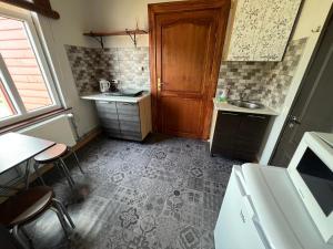 cocina con fregadero y puerta de madera en Dzintari en Ventspils