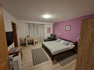 1 dormitorio con cama y pared púrpura en Guest house Wolf II en Plitvička Jezera