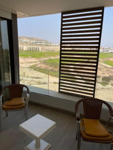 une chambre avec deux chaises, une table et une fenêtre dans l'établissement Appartement De Luxe à Taghazout, à Agadir