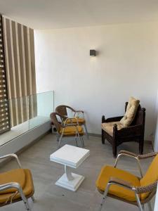 uma sala de espera com cadeiras, uma mesa e um sofá em Appartement De Luxe à Taghazout em Agadir