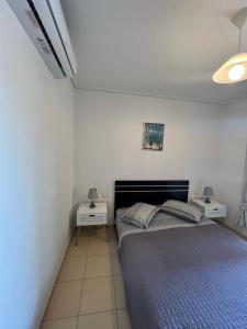 een slaapkamer met een bed en twee nachtkastjes bij Luxury Studio Artemida in Artemida