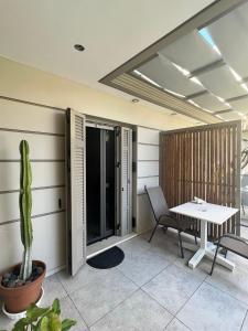 Habitación con mesa, sillas y cactus en Luxury Studio Artemida, en Artemida