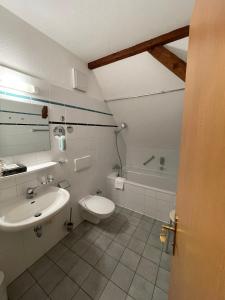ein Badezimmer mit einem Waschbecken, einem WC und einer Badewanne in der Unterkunft Hotel Luther Birke Wittenberg in Lutherstadt Wittenberg
