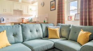 um sofá azul numa sala de estar com almofadas amarelas em Thirlmere em Sawrey
