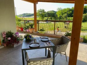 a table and chairs on a patio with a view of a field at Cruna di Subida Wine Country House in Cormòns
