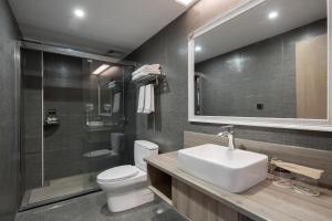 a bathroom with a sink and a toilet and a shower at Morninginn, Phoenix Ancient City Tuojiang in Fenghuang
