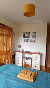 a bedroom with a bed with a desk and a blanket at Ard na Greine Bed & Breakfast Ballylickey in Ballylickey