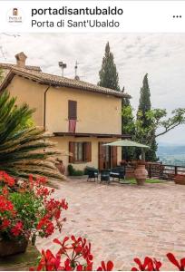 a house with a patio with a table and an umbrella at Umbrian cottage in Gubbio