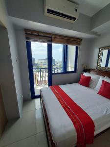 a bedroom with a large bed with a large window at Sea Residences Holiday Rentals in Manila