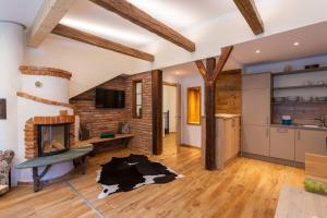 a living room with a fireplace and a kitchen at Smileys Fluss Chalet in Trebesing