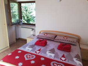 um quarto com uma cama com cobertores e almofadas de Natal em Cèsa Pier Sellaronda Dolomiti em Campitello di Fassa