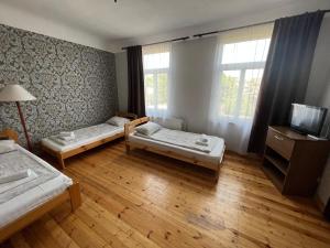 a room with two beds and a flat screen tv at Dzintari in Ventspils