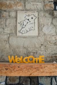 a sign on a stone wall with a welcome sign on a bench at Creevy Cottages in Rossnowlagh