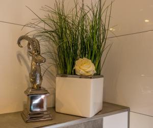 a plant in a white vase next to a trophy at Willma Apartmenthaus in Beelen