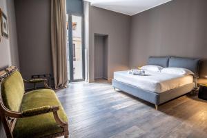 a bedroom with a bed and a chair and a couch at Palazzo Zippitelli Apartments in Bari