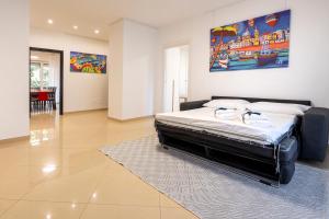 una camera da letto con un letto e un dipinto sul muro di Boscoincittà Apt with garage and whirlpool tub a Bari