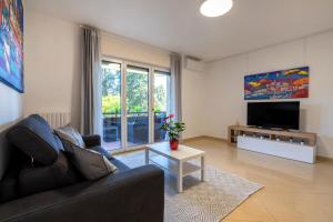 un soggiorno con un divano e una TV di Boscoincittà Apt with garage and whirlpool tub a Bari