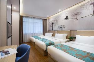 una camera d'albergo con 3 letti e una scrivania di Morninginn, Phoenix Ancient City Tuojiang a Fenghuang