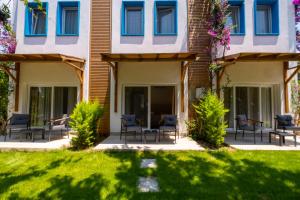 a house with blue windows and a lawn at Costa Bodrum City in Bodrum City +113 photos