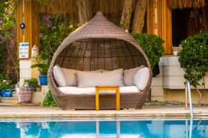 a wicker swing with a couch sitting next to a pool at Costa Bodrum City in Bodrum City