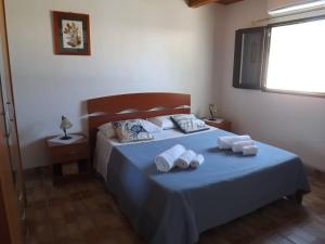 a bedroom with a blue bed with towels on it at Case Vacanze Villa Lory in Malfa