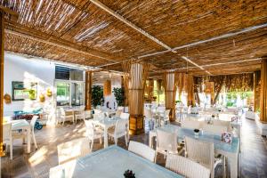 a restaurant with white tables and chairs and a ceiling at Costa Bodrum City in Bodrum City