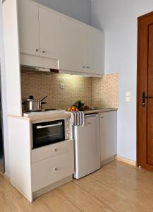 a kitchen with white cabinets and a stove at Stella in the Village - Junior Studio Sea View in Plakias