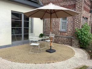 een tafel en stoelen onder een parasol op een patio bij Ghenttower in Gent
