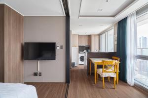 a hotel room with a bed and a table and a television at Flat nearby Heaundae beach in Busan