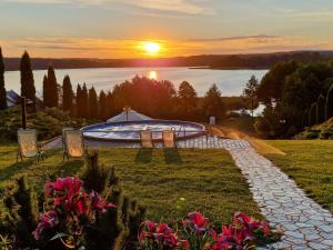 a garden with a swimming pool and the sunset at Willa Dąbrowa in Dąbrówno