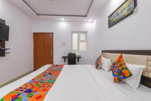 1 dormitorio con 1 cama grande y escritorio en FabHotel A One Inn, en Lucknow