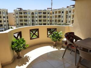 a balcony with two potted plants and a building at ستيلا هايتس الساحل الشمالي in Sīdī ‘Abd ar Raḩmān