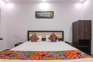 勒克瑙FabHotel A One Inn的一间卧室配有一张带彩色毯子的床