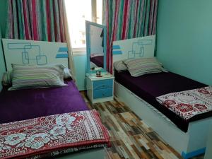 um quarto com duas camas e um espelho em ستيلا هايتس الساحل الشمالي em Sīdī ‘Abd ar Raḩmān