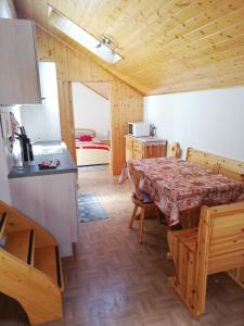 uma cozinha e sala de jantar com uma mesa num quarto em Cèsa Pier Sellaronda Dolomiti em Campitello di Fassa